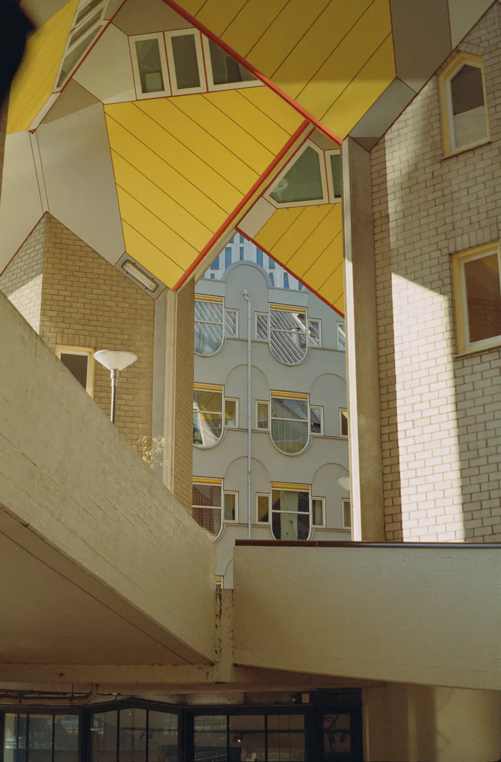 hochkantiges farbiges bild mehrerer häuser mit vielen ecken und kanten und fenstern und farbe und beton. die perspektive ist nicht klar und selbst die bildbeschreibung macht kopfschmerzen. bin mir nicht mal sicher, ob das richtig herum ist. man stelle sich vor, man muss da putzen, meine güte.