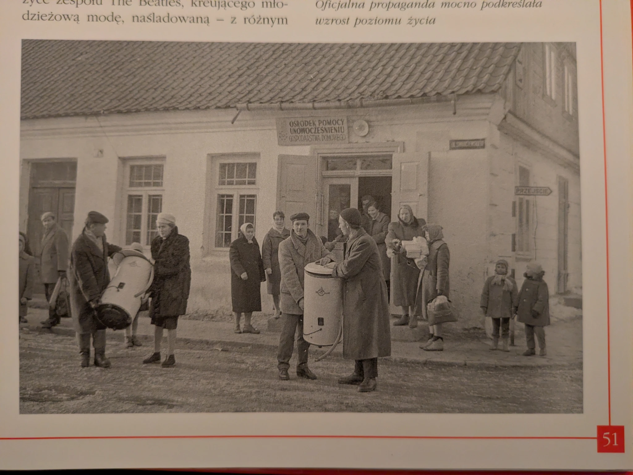 schwarzweißes foto in einem buch, keine datierung. menschen tragen schleidern oder boiler vor einem haus. 