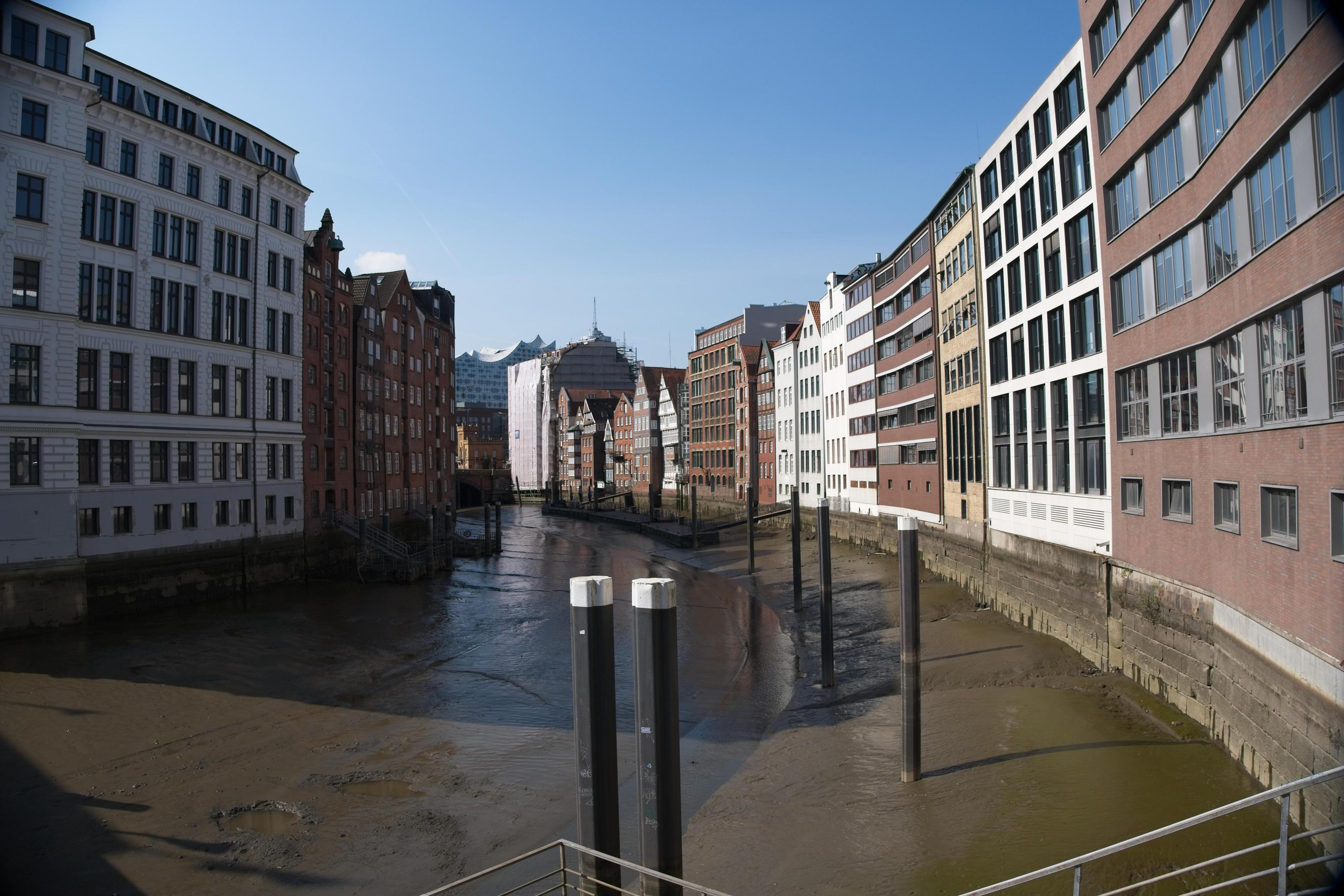 Foto eines Kanals bei Ebbe. Gebäude umschließen den Kanal