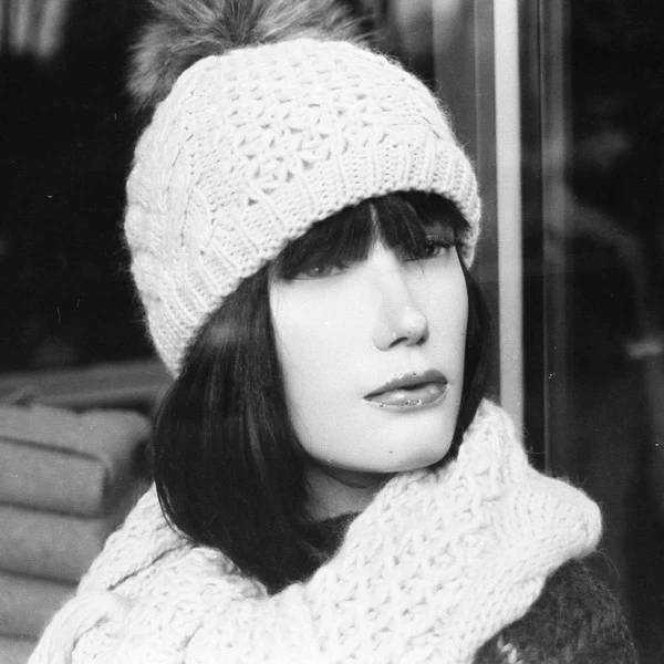 black and white picture of mannequin with winter clothing. only on second glance we see it's artificial.