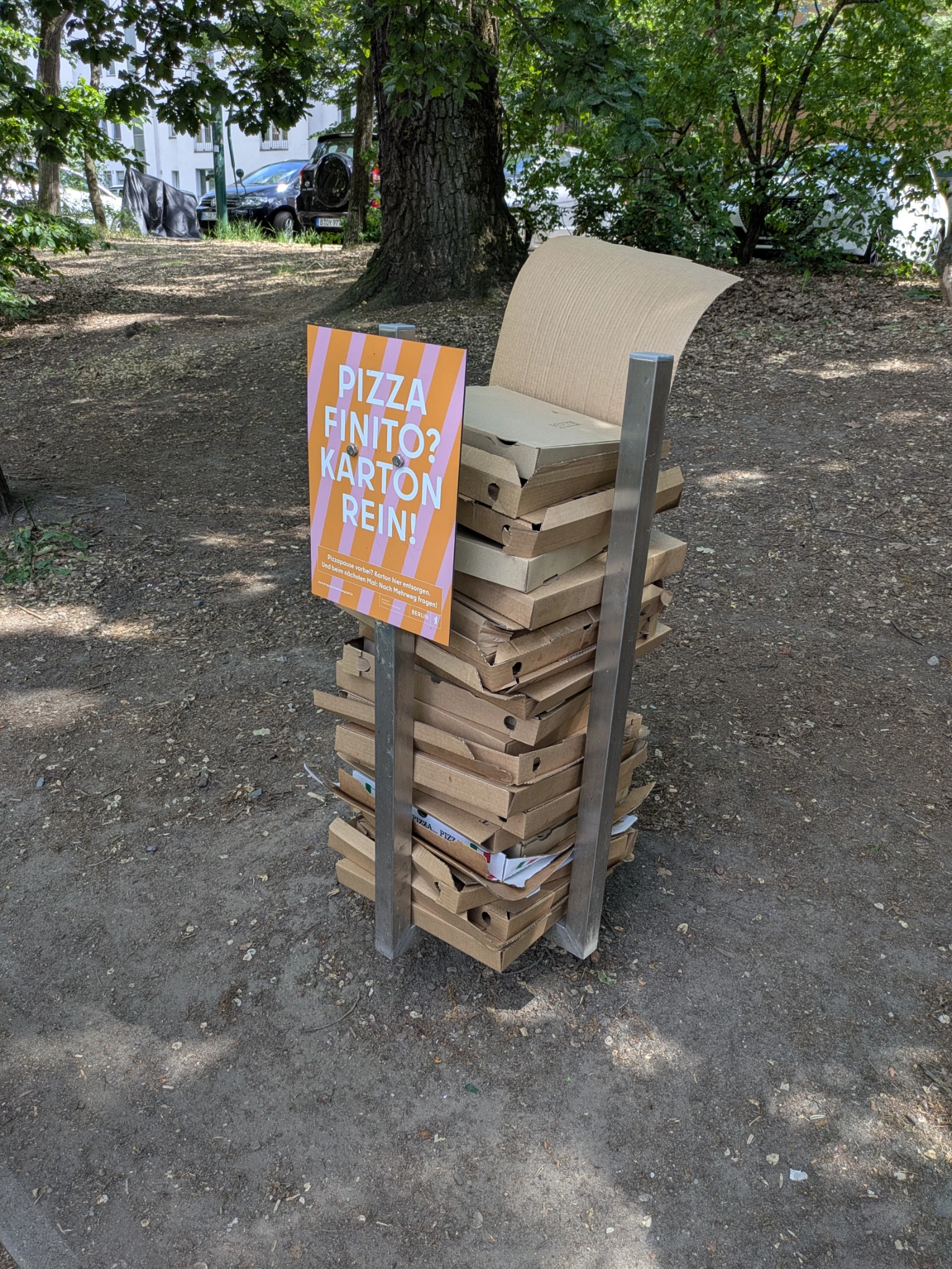 ein merkwürdiges konstrukt für leere pizzaschachteln im öffentlichen raum, gut gefüllt mit pizzaschachteln 