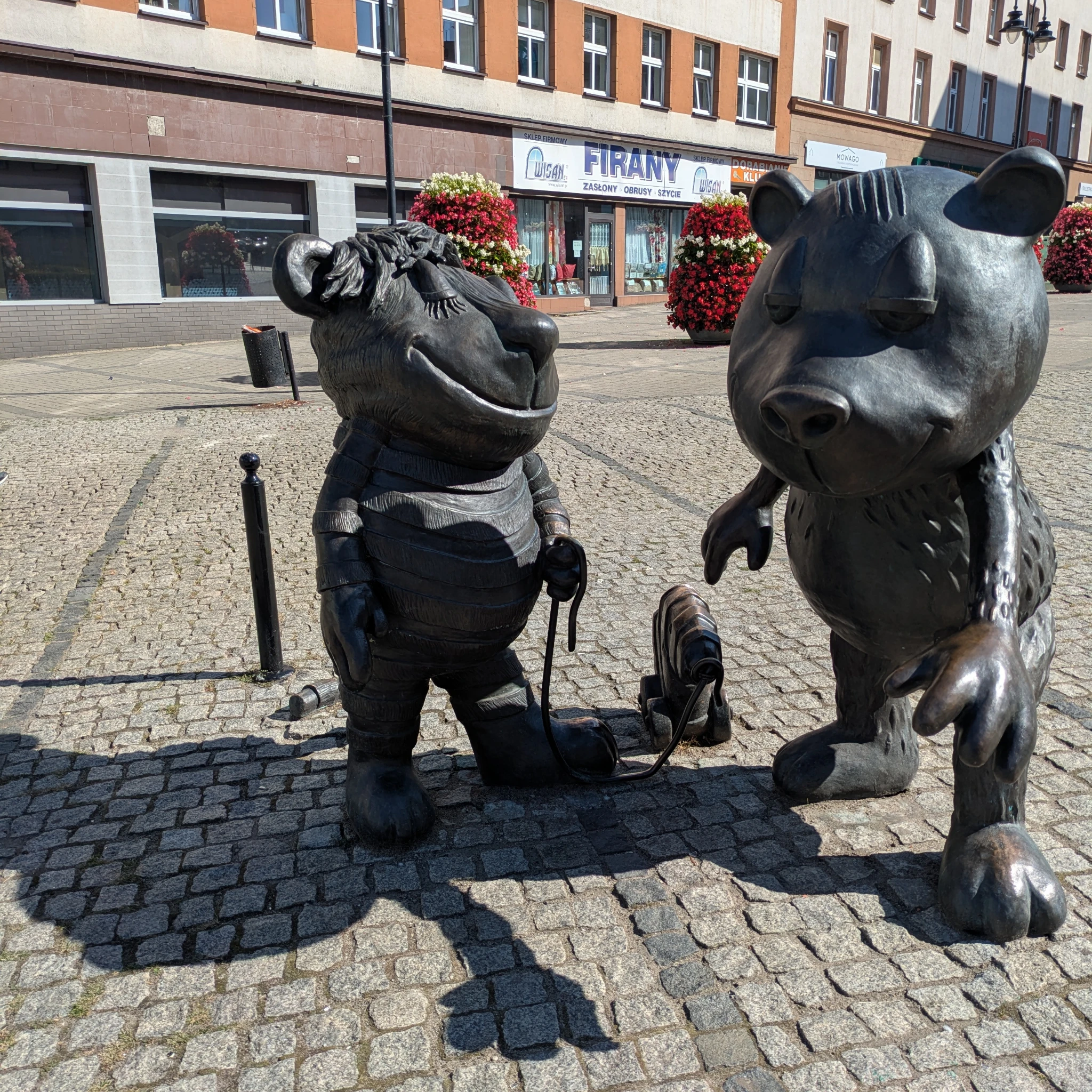 Tieger Bär und Tigerente aus Metall auf einem gepflasterten Platz.