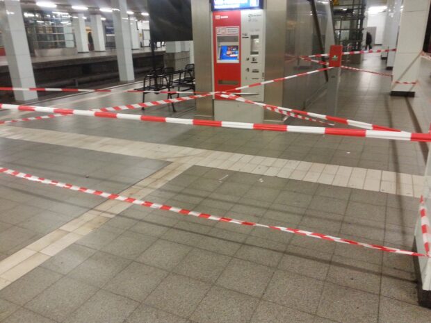 auf einem Bahnsteig hängt wild rotweißes flatterband, unklar, warum